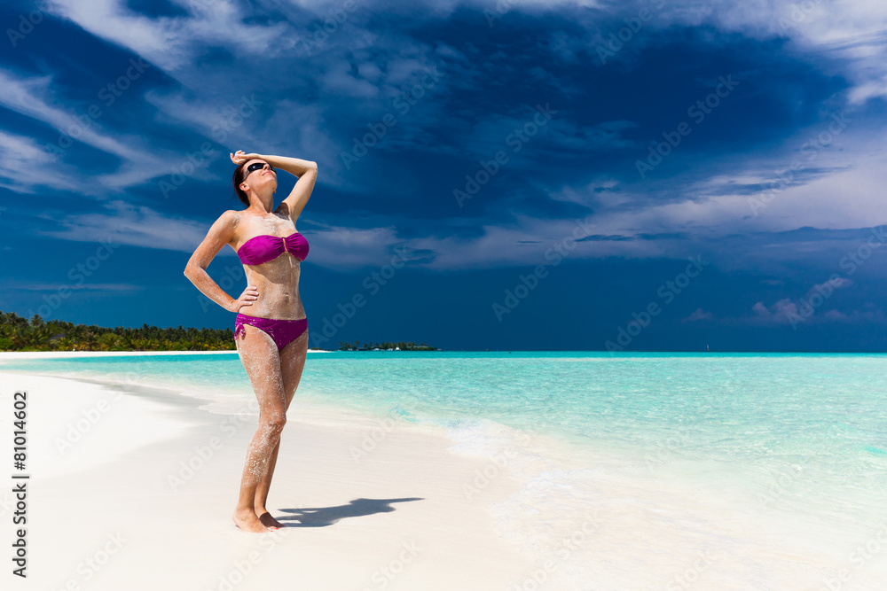 Woman in purple bikini covered in sand on tropical beach Woman in purple bikini covered in sand on tropical beach