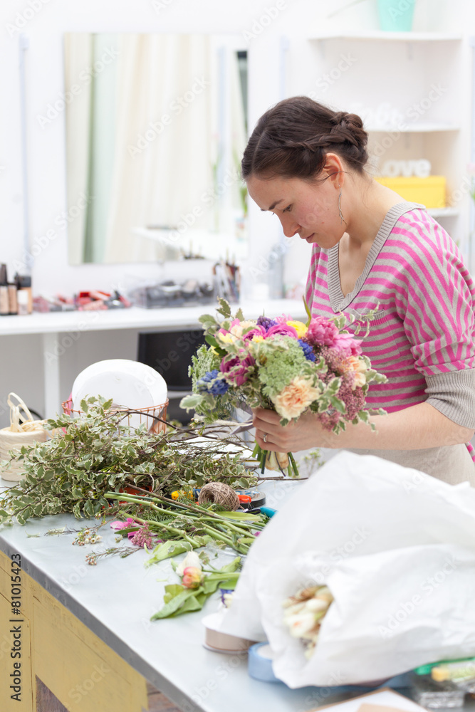 Masterclass of smiling florist at work with bunch of flowers