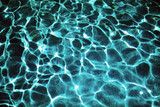 Dark ripped water in swimming pool with sun reflections