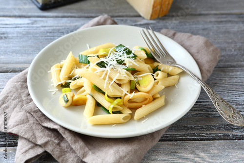 Tasty pasta with cheese and onions on a white plate