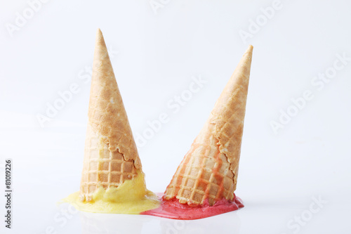 yellow passion fruit and red strawberry ice cream cones dropped