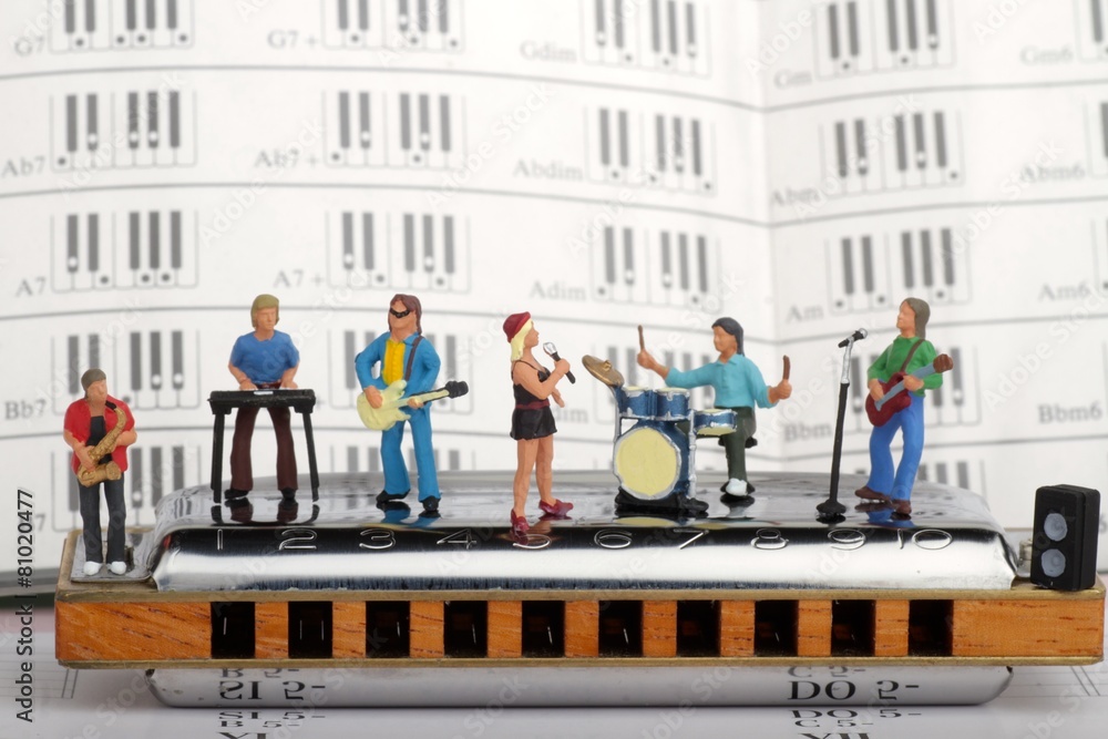gruppo rock in miniatura mentre suona su un'armonica a bocca