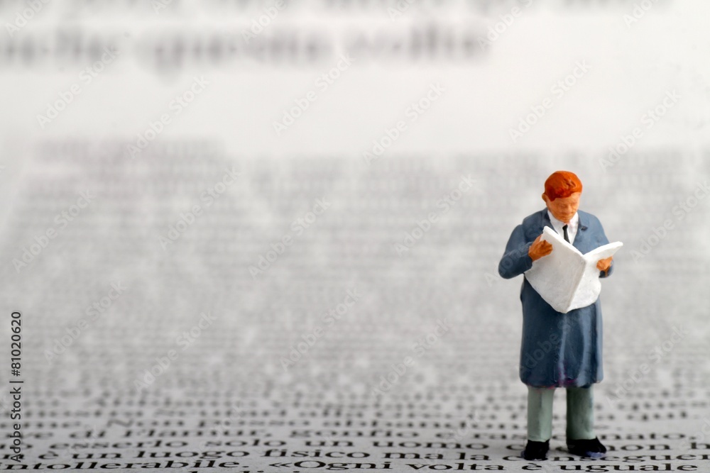 Fototapeta premium miniatura di uomo d' affari che legge il giornale