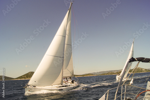 two yachts sail in pursuit of the leader