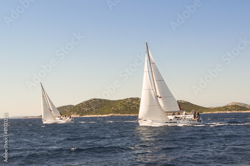 two yachts under sail with a large roll