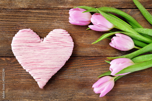 Beautiful pink tulips with decorative heart on wooden