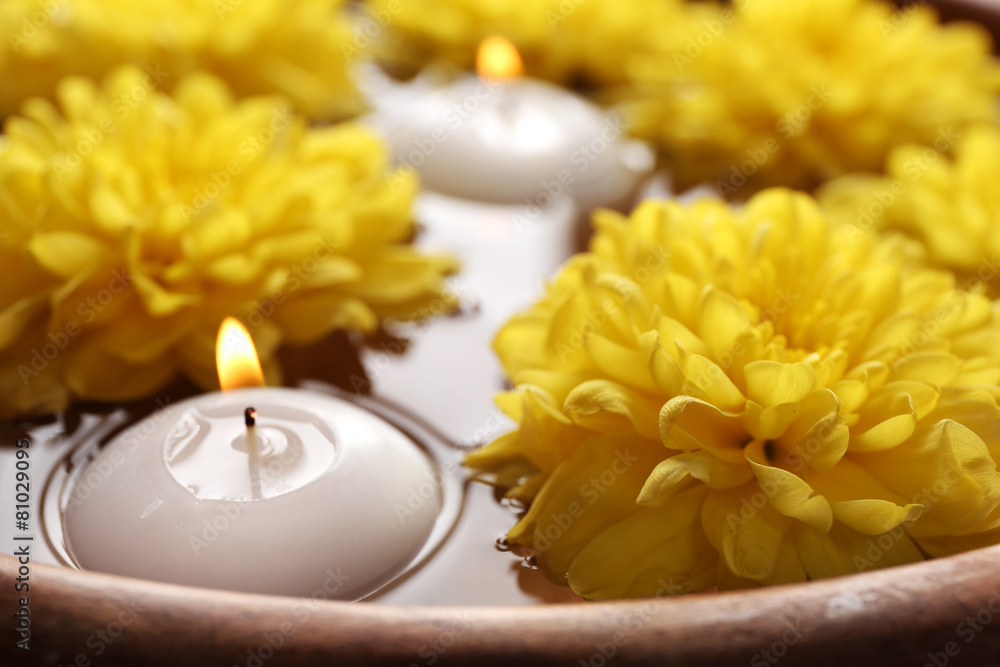 Bowl of spa water with flowers and candles, closeup Bowl of spa water with flowers and candles, closeup