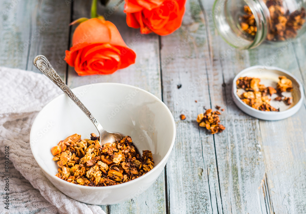 Fototapeta premium homemade granola with nuts and dried fruit, honey, flowers
