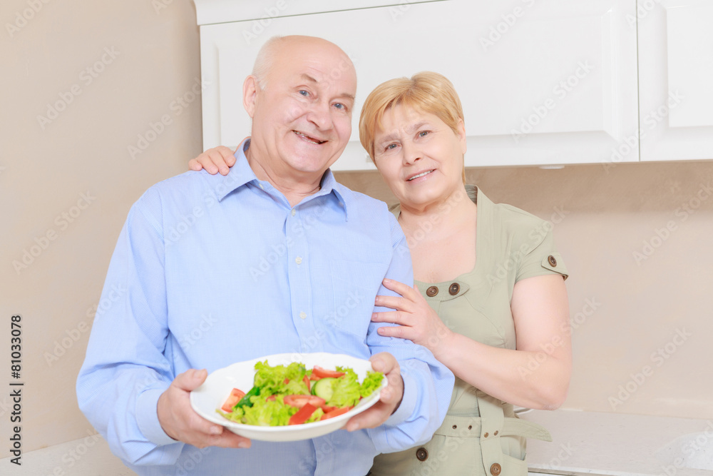 Couple holds a plate with salad Couple holds a plate with salad
