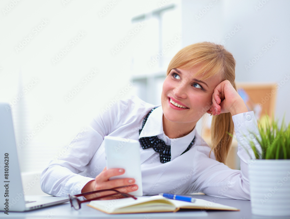 Portrait of businesswoman sitting at desk with a laptop Portrait of businesswoman sitting at desk with a laptop