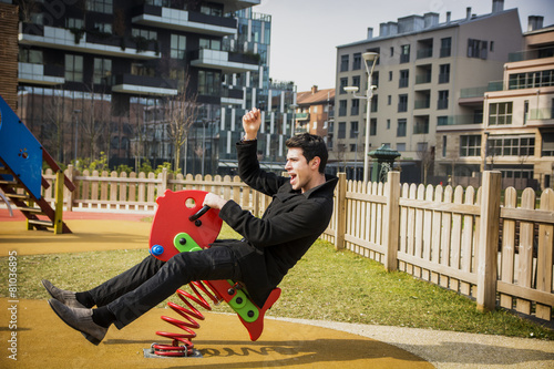 Картината върху платно Young man reliving his childhood plying in a children's