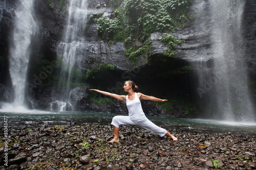 woman meditating doing yoga between waterfalls