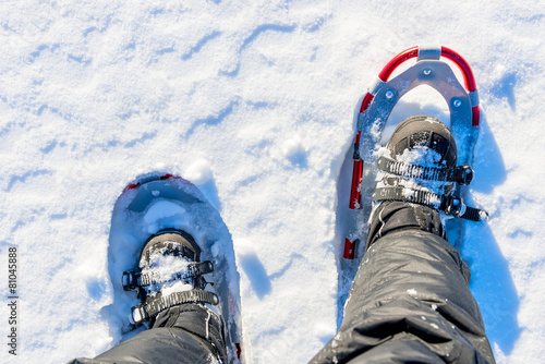 men legs are shod with snowshoes on the snow photo