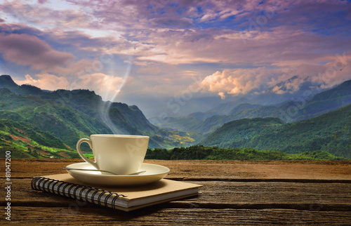 Morning cup of coffee with mountain background at sunrise