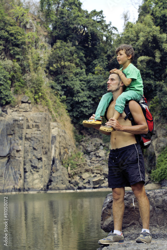 father and son making a trip to waterfall together, happy family photo