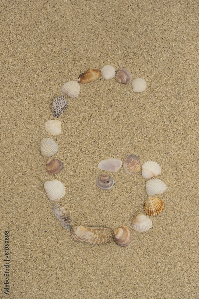 Buchstabe G aus Muscheln im Sand Buchstabe G aus Muscheln im Sand