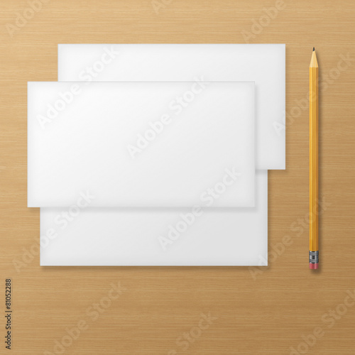 Set of blank envelopes with yellow pencil on wooden background.