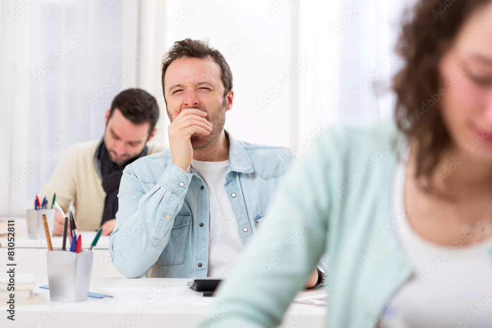 Fototapeta premium Young attractive student yawn during classes
