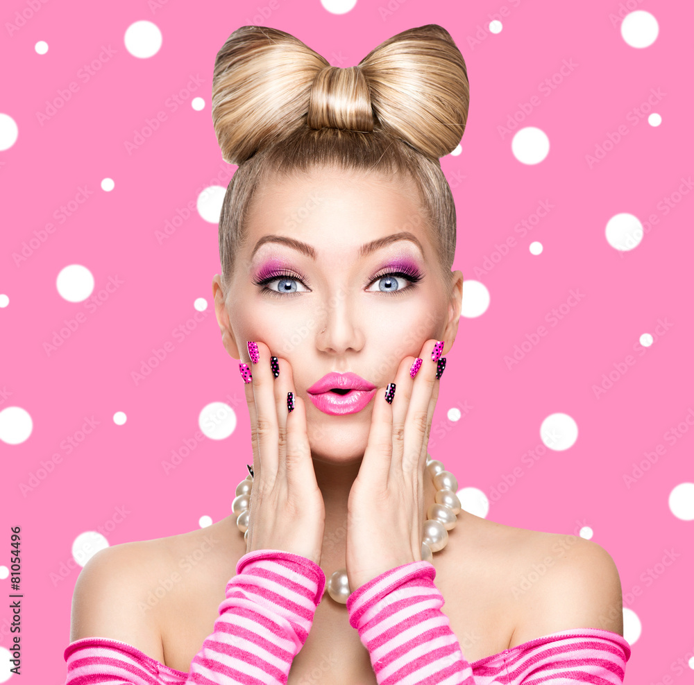 Fototapeta premium Beauty model girl with bow hairstyle over polka dots background