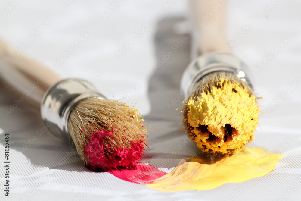 Deux pinceaux, peintures rouges et jaunes