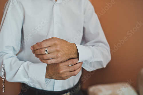 The young man dresses cuff links on a shirt 2231.