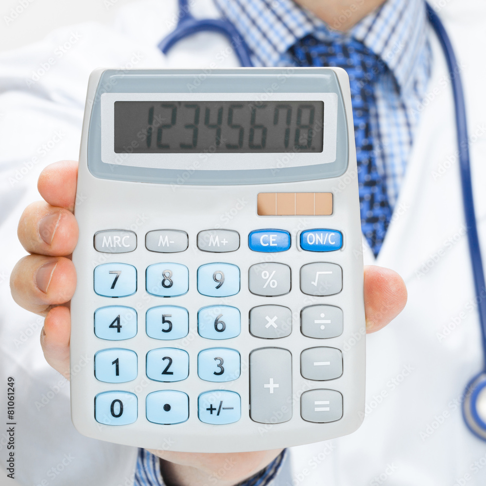 Doctor holding calculator in hand - studio shot Doctor holding calculator in hand - studio shot