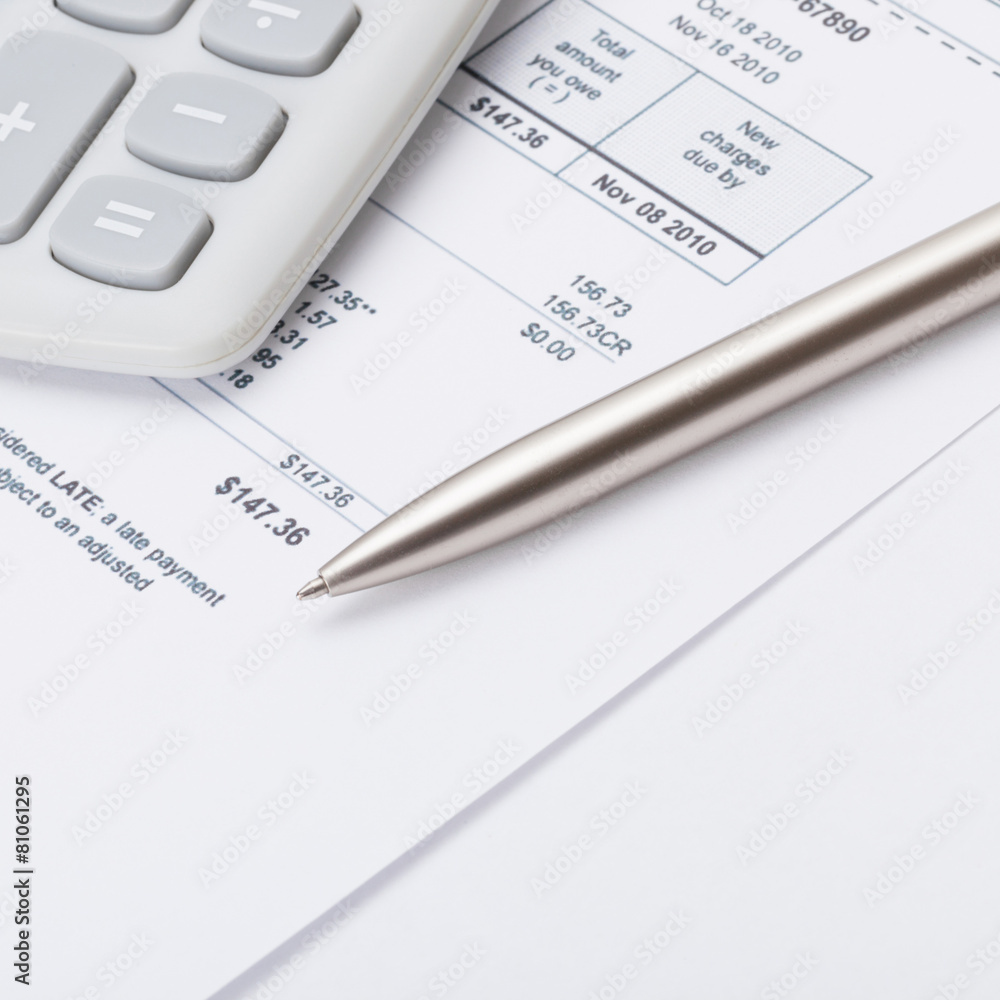 Calculator with silver pen and utility bill - close up shot Calculator with silver pen and utility bill - close up shot
