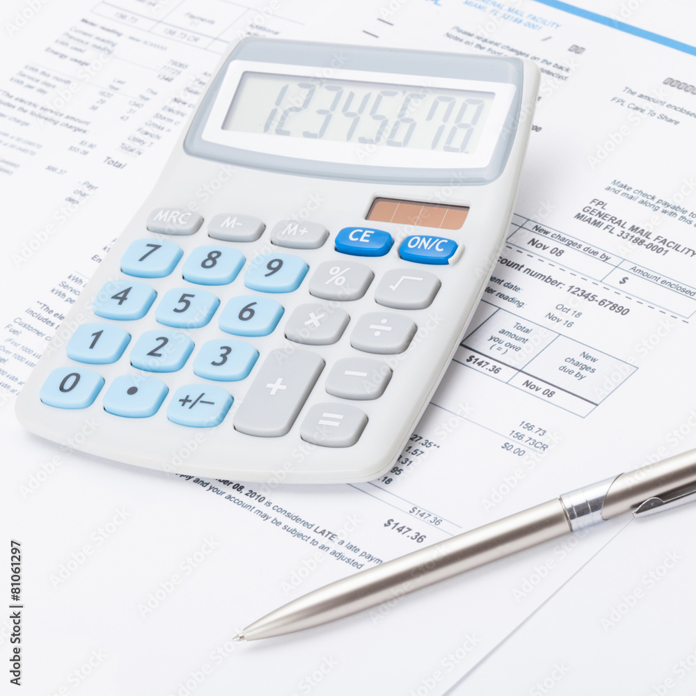 Neat calculator with silver pen and utility bill - close up shot Neat calculator with silver pen and utility bill - close up shot