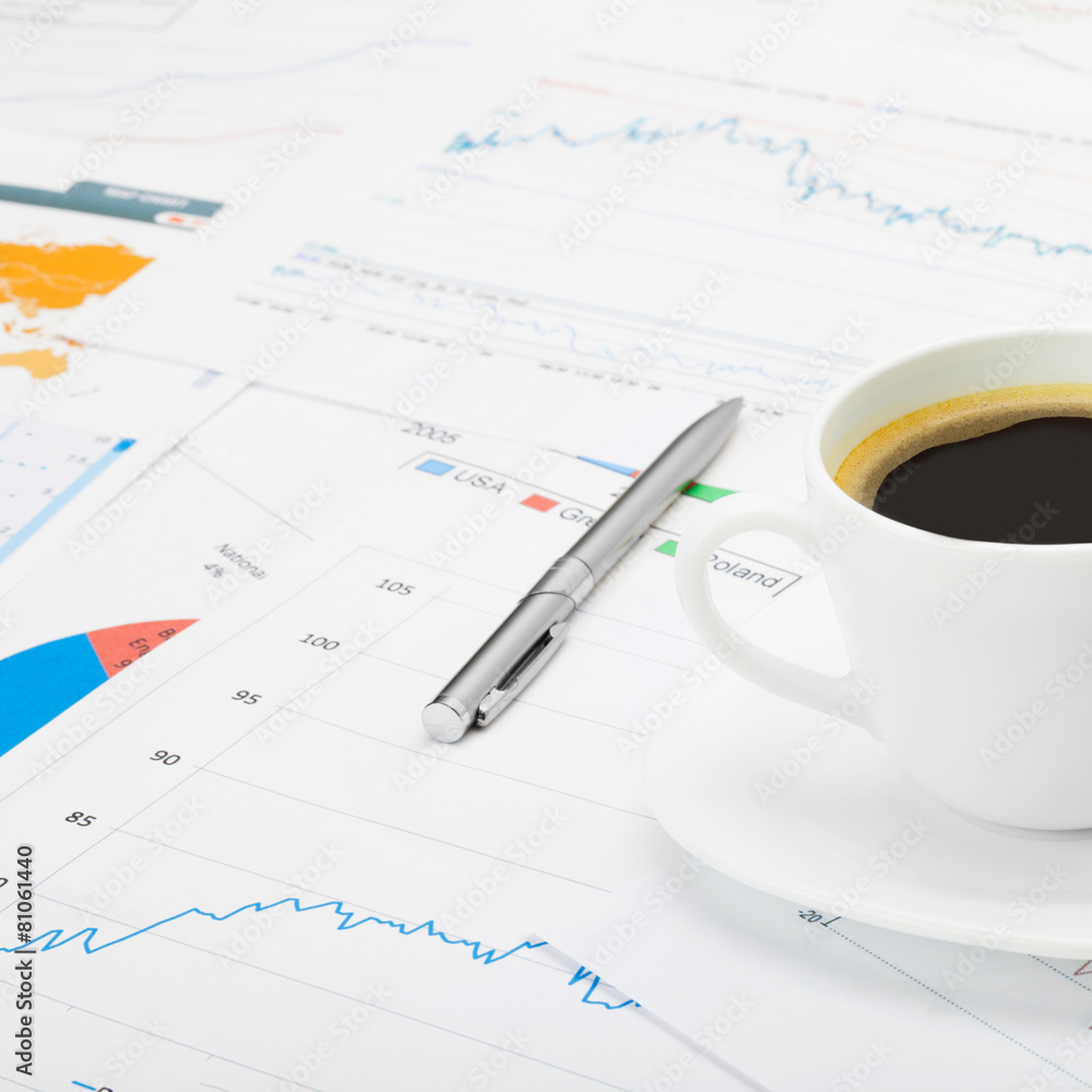 Coffee cup and calculator over some financial chart Coffee cup and calculator over some financial chart