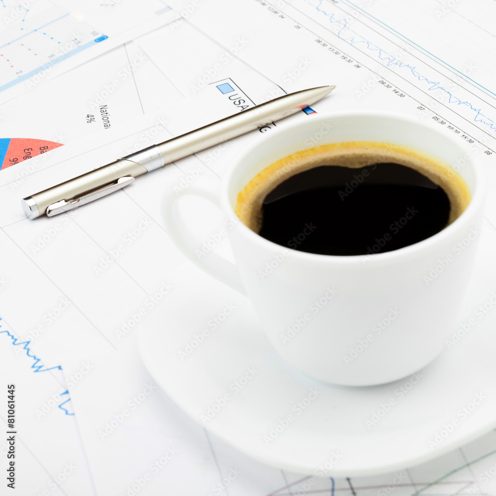 Coffee cup and calculator over some financial charts Coffee cup and calculator over some financial charts