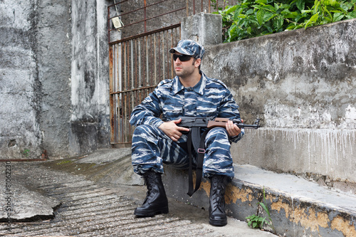 Caucasian military man with black sunglasses in urban warfare si
