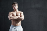 Strong man with athletic body looking at the camera