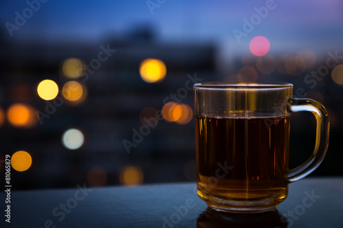 Tea cup in front of night city lights