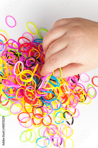 Little child hand and pile of small colorful rubber bands