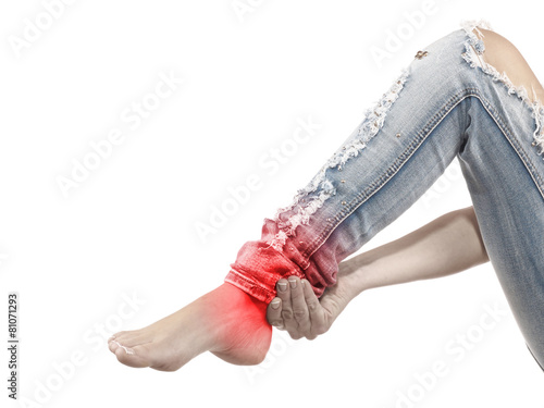 A young woman massaging her painful ankle
