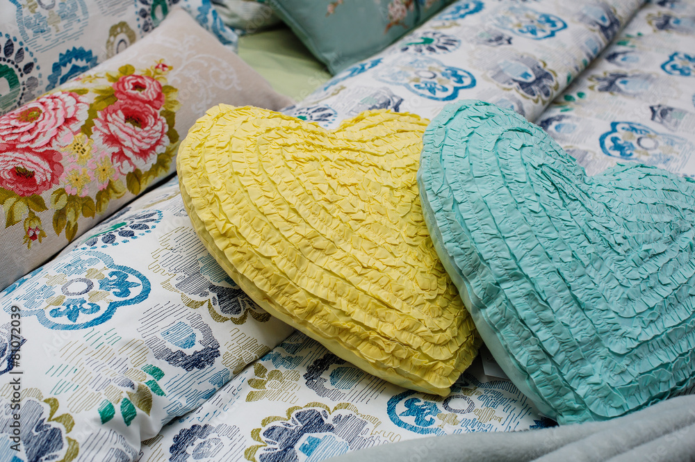 Two pillows in the form of hearts lie on the bed