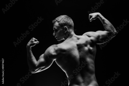 Close up of sports man's muscular isolated on black background © satyrenko