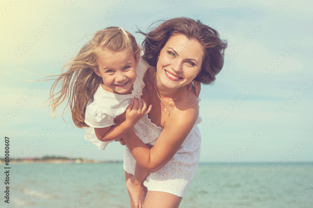 Fototapeta premium Mother and her daughter having fun on the beach