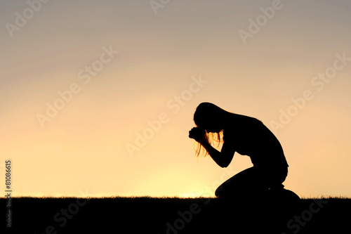 Fototapeta Christian Woman Sitting Down in Prayer Silhouette