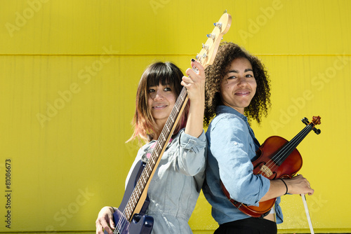 Photography Women musicians standing back to back with instruments
