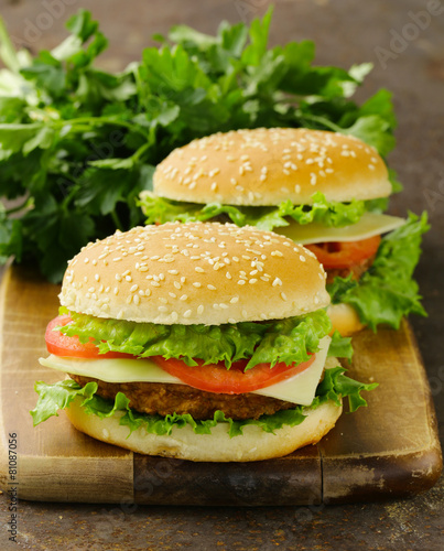 traditional cheeseburger with green lettuce and tomatoes