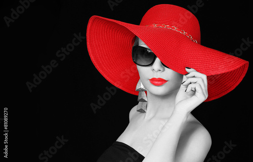 Φωτογραφία Woman in red hat and sunglasses over black background