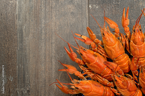 Plate of red crayfishes on old wooden table