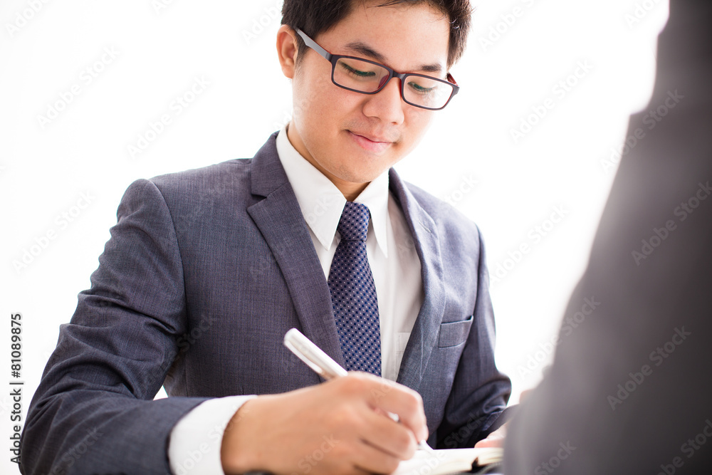 Two businessmen looking at report and having a discussion in off Two businessmen looking at report and having a discussion in off