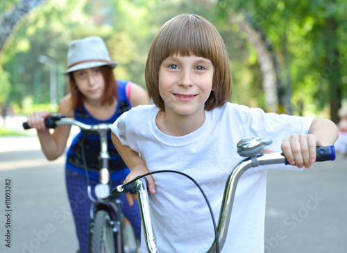Two children with bicycles bike in park. Childhood, happiness, a