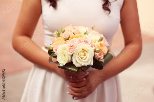 Bride holding bouquet of roses