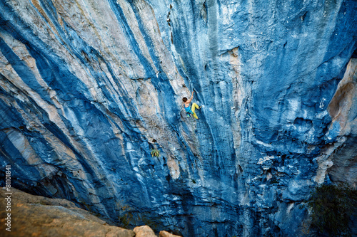 Rock climber climbing up a cliff