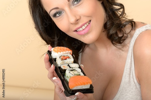 Beautiful Young Woman Looking at the Camera Holding Sushi