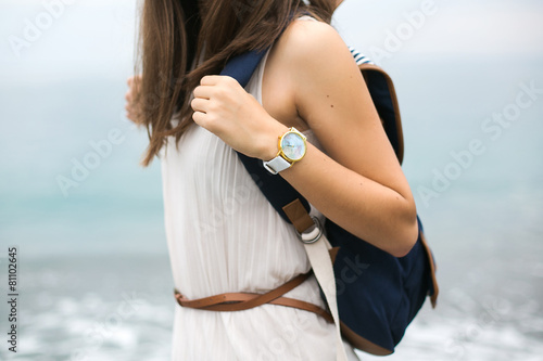 girl with a backpack and a clock traveler