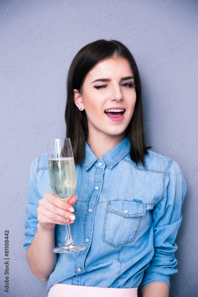 Woman holding glass of champagne and winking Woman holding glass of champagne and winking